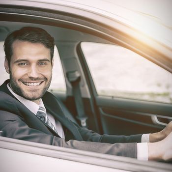 Man sitting in a car smiling and looking at camera