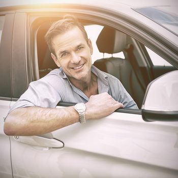 man smiling at camera in a car 