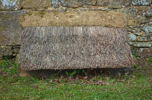 Old style cane canopy next to an stone wall