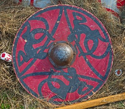 Medieval round wooden shield on hay