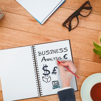 Hand writing with a pencil against close up view of business stuff