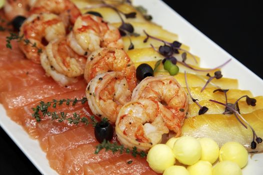 Assorted shrimp, trout and oily fish with balls of oil and black olives