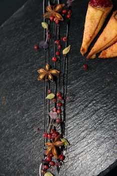 Rabbit pate in crispy horns decorated with spices on a black stone plate