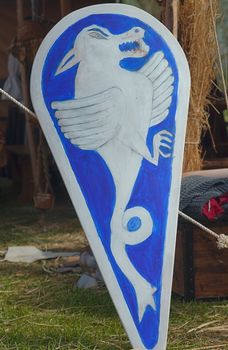Medieval blue and white wooden shield with painted dragon
