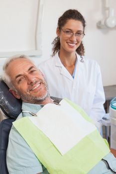 Patient and dentist smiling at camera at the dental clinic