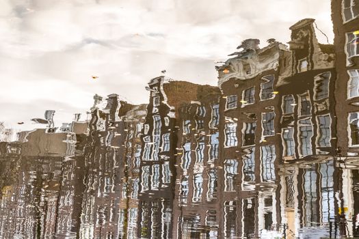 Amstedam, capital of Netherlands. Water reflections of traditional houses by the street canal.