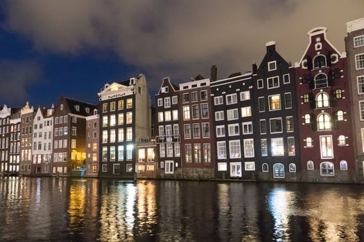 Amstedam, capital of Netherlands. Beautiful tranquil scene of city of Amsterdam at dusk. Bicycles along the street and on the bridge over the canal.