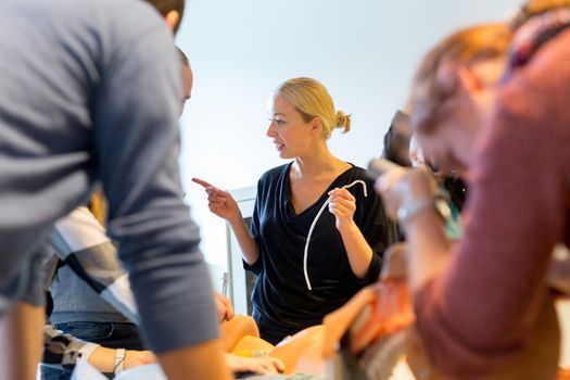 Medical doctor expert instructor displaying method of patient intubation on medical education training and workshop. Participants working in teams learning new medical procedures and techniques.