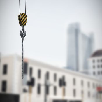 Studio Shoot of a crane lifting hook against view of apartment