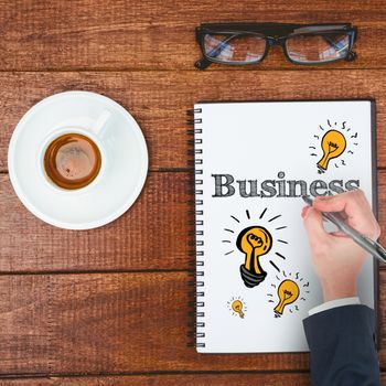 Hand writing with a pen against above view of business desk