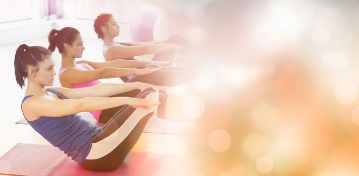 Side view of class stretching on mats at yoga class in fitness studio