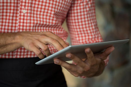 Midsection of man using digital tablet outdoors