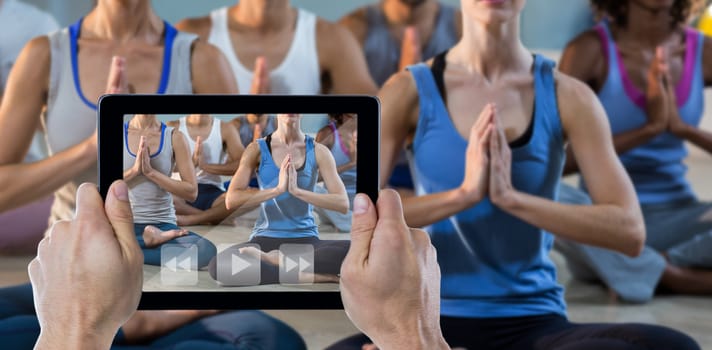 Cropped hand holding digital tablet against low section of people performing yoga