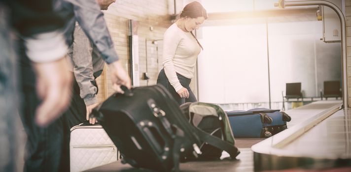 People carrying luggage from baggage claim at airport