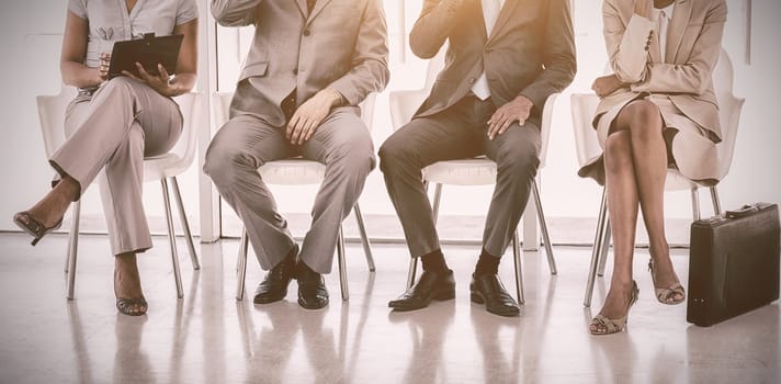 Group of business people sitting in waiting room in office