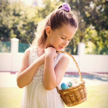 Little girl collecting easter eggs outside in the garden