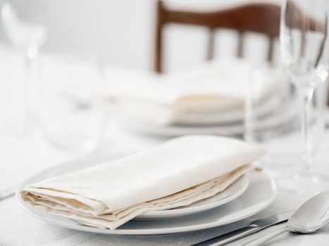 Beautiful table setting in white colors. Empty white plates. Set table for romantic dinner for two at home