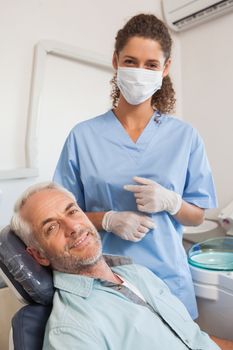 Patient and dentist smiling at camera at the dental clinic