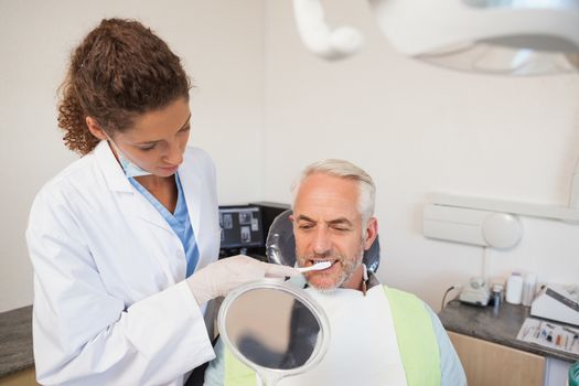 Patient admiring his new smile in the mirror at the dental clinic