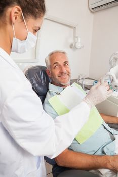 Patient smiling at dentist in the chair at the dental clinic