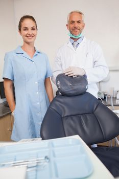 Dentist and assistant smiling at camera at the dental clinic