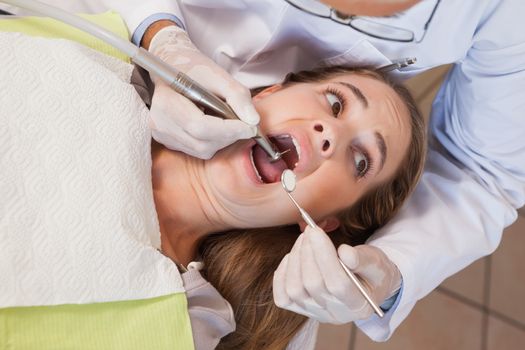 Dentist about to pull a terrified patients tooth at the dental clinic