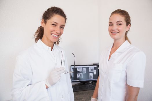 Dentist and assistant studying x-rays on computer at the dental clinic