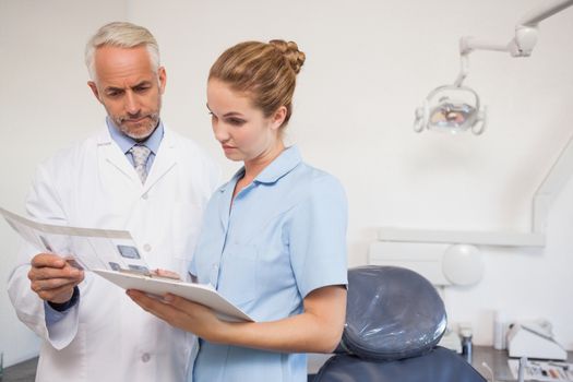 Dentist and assistant studying x-rays at the dental clinic