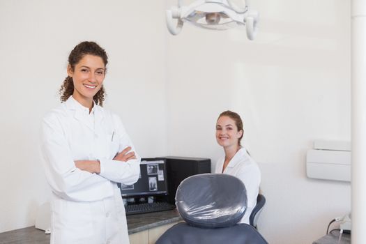 Dentist and assistant smiling at camera at the dental clinic