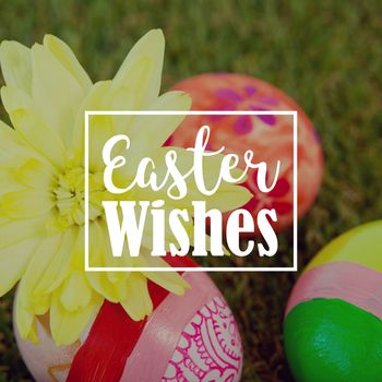 Easter greeting against painted easter eggs with flowers on grass