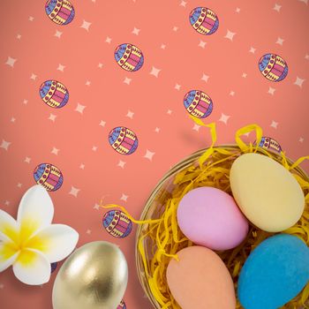 Close-up of frangipani against colorful easter eggs in wicker basket nest