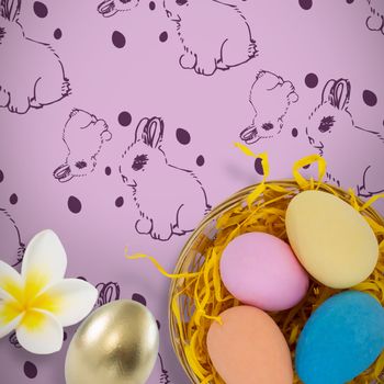 Close-up of frangipani against colorful easter eggs in wicker basket nest