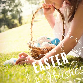 Little girl collecting easter eggs against easter wishes logo