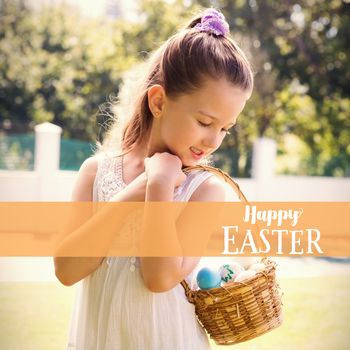 Little girl collecting easter eggs against easter greeting
