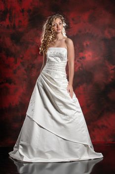 Young beautiful woman in a wedding dress on a studio background