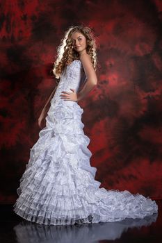 Young beautiful woman in a wedding dress on a studio background