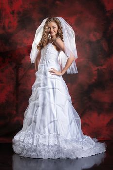 Young beautiful woman in a wedding dress on a studio background