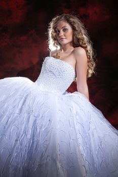 Young beautiful woman in a wedding dress on a studio background