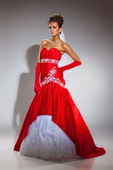 Young woman in a weddng dress on a studio background