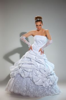 Young beautiful woman in a wedding dress on a studio background