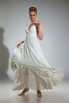 Young beautiful woman in a wedding dress on a studio background