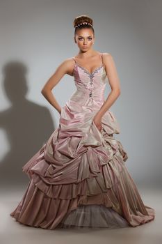 Young beautiful woman in a wedding dress on a studio background