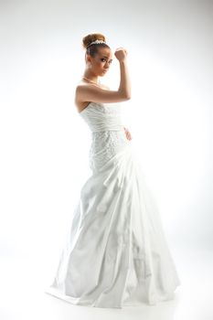 Young beautiful woman in a wedding dress on a studio background