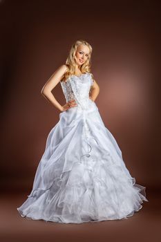 Young beautiful woman in a wedding dress on a studio background