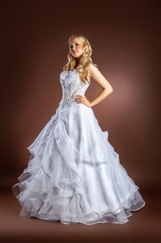 Young beautiful woman in a wedding dress on a studio background