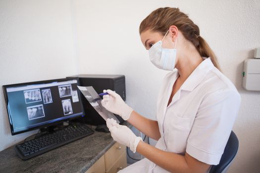 Dental assistant looking at x-rays on computer at the dental clinic