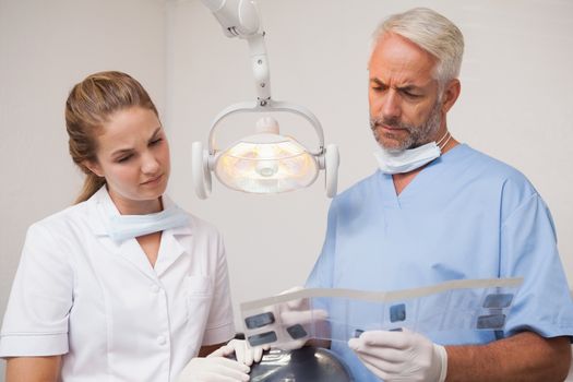 Dentist and assistant studying x-rays at the dental clinic