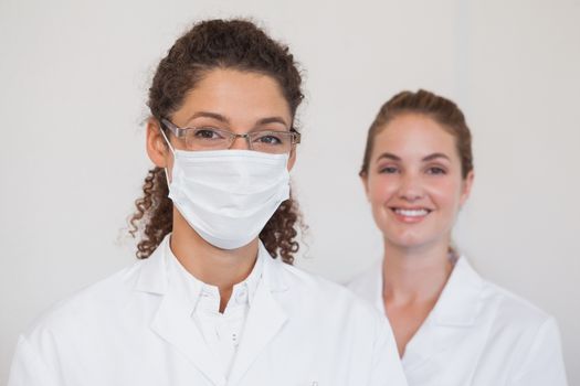 Dentist and assistant smiling at camera at the dental clinic