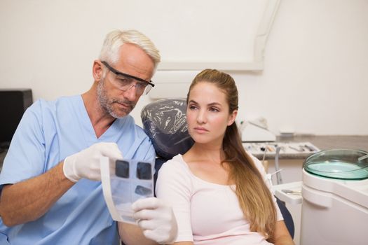 Dentist showing patient her xrays at the dental clinic