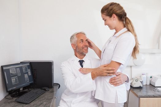 Dentist and dental assistant embracing inappropriately at the dental clinic